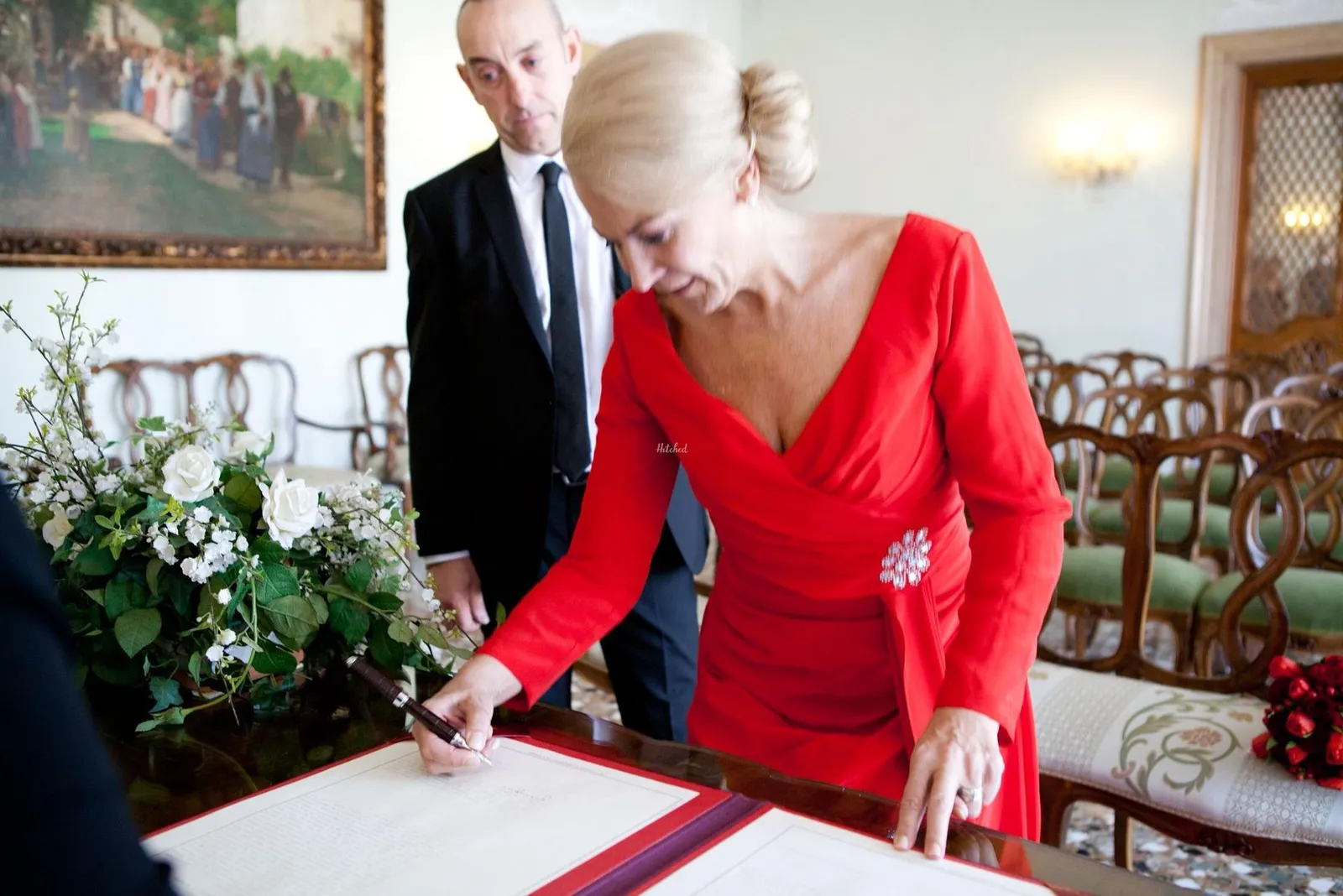Bride signing the register in a red dress