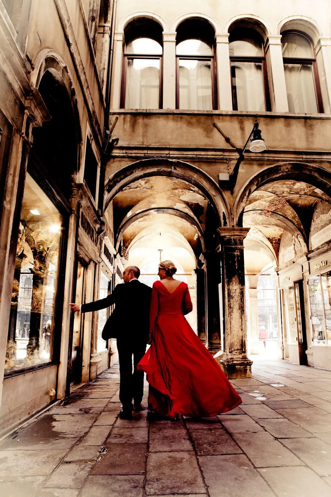 Newlyweds walking together under stone arches