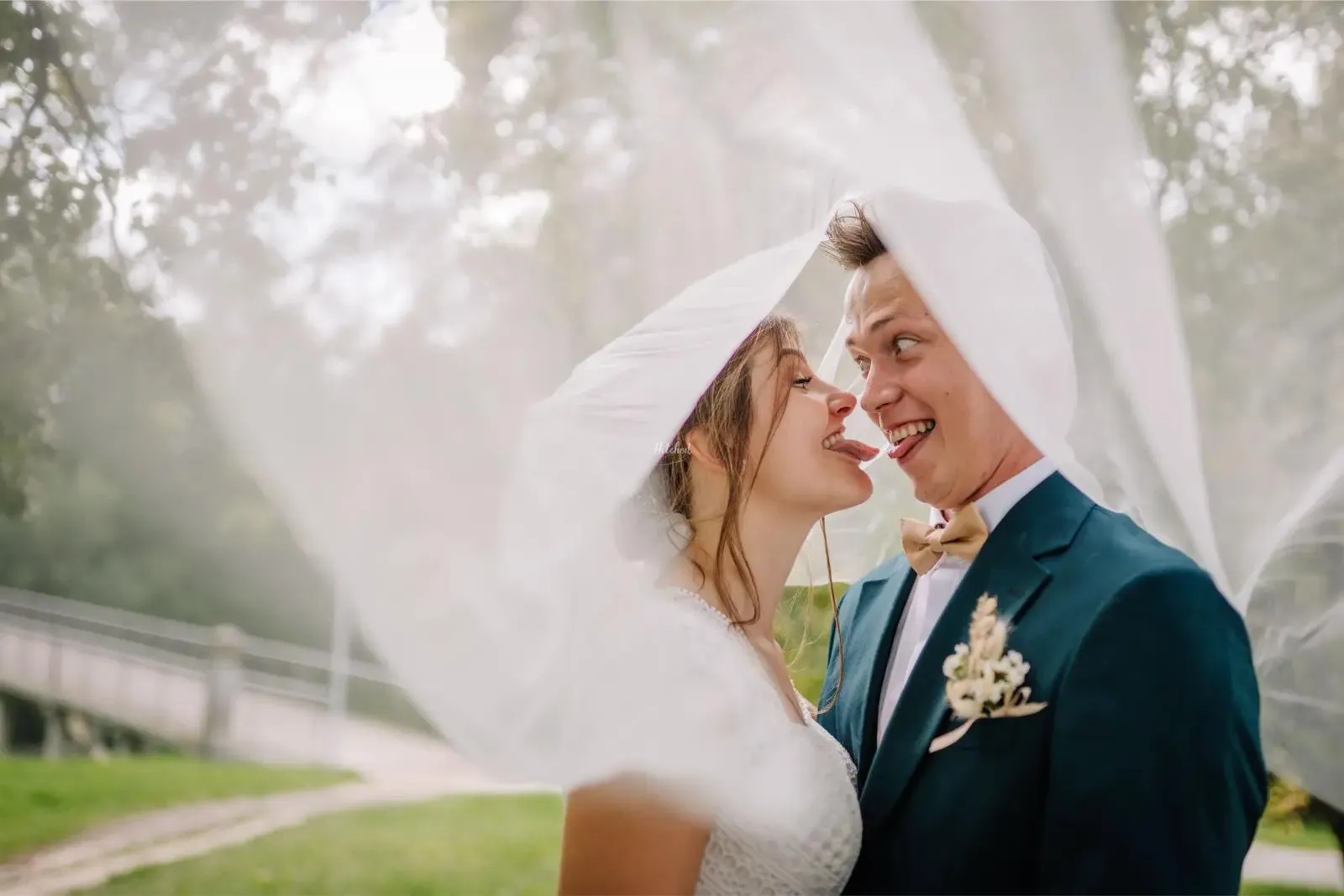 Couple sharing a playful moment under the veil